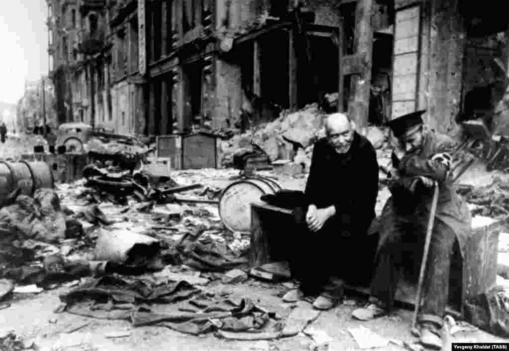 Слепой мужчина (справа) с проводником на разрушенной улице Берлина в 1945 году. Халдей вспоминал, что спросил мужчину на немецком, откуда они пришли. Слепой ответил: &quot;Мы больше не знаем. Мы не знаем, откуда мы пришли, или куда мы идем&quot;