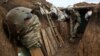 UKRAINE -- A Ukrainian serviceman digs the ground of a trench as he stands at his post on the frontline with Russia backed separatists near the town of Zolote, in the Luhansk region, April 8, 2021