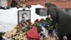 A woman lays flowers at the grave of Russian opposition leader Alexei Navalny at the Borisovo cemetery in Moscow on February 16, 2026, the anniversary of his death in an Arctic colony.
