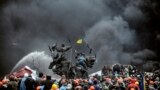 Ukraine -- Protesters stand behind barricades during a face-off against police in Kyiv, February 20, 2014
