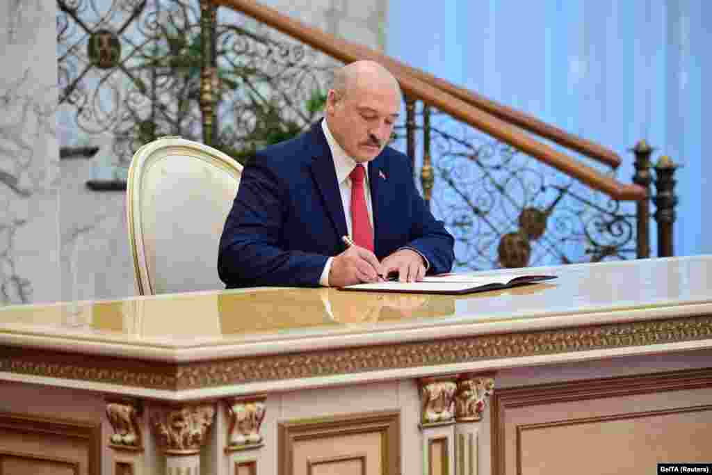 Лукашенко подписывает документ после присяги