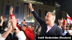 Former TV news anchor Zaal Udumashvili, one of the leaders of the United National Movement party, cheers as party supporters gather in front of Georgia's parliament building to "monitor" the vote count in the country's October 31, 2020 parliamentary election.