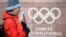 SWITZERLAND -- A supporter stands with a Russian flag in front of the logo of the International Olympic Committee (IOC) at the headquarters on December 5, 2017 in Pully near Lausanne.