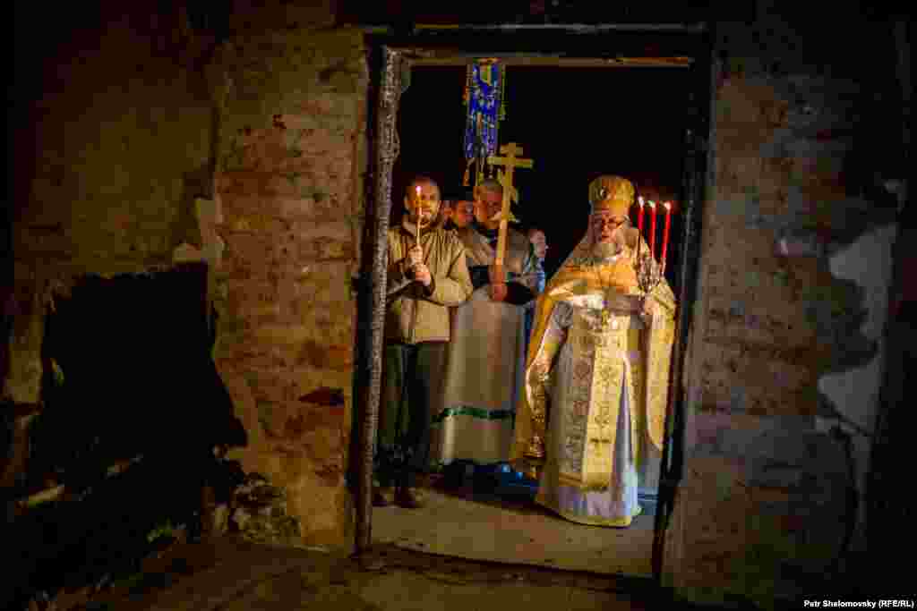 Священник служит Пасхальную службу в разрушенном артиллерией храме в Петровском районе Донецка