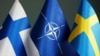GENERIC – Flags of Sweden and Finland against the background of the symbol of NATO