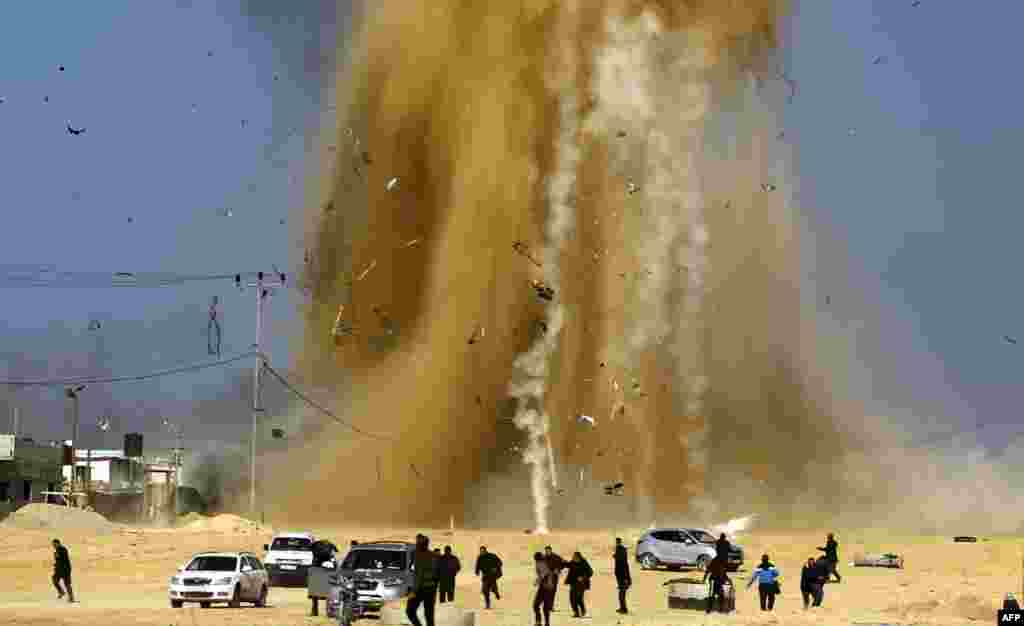 Палестинцы убегают от взрыва после израильского воздушного удара по посту ХАМАС на севере Сектора Газа, 6 февраля (AFP/Mohammed Abed)