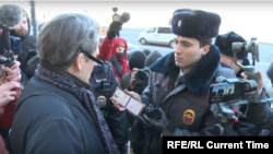 Полицейский показывает свои документы участнику протеста напротив здания Конституционного суда в Петербурге