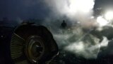 Мужчина ходит по останкам малайзийского авиалайнера, сбитого около города Шафтарска на востоке Украины, на территории, контролируемой сепаратистами. 17 июля. В результате катастрофы самолета погибли все находившиеся на борту 298 человек.&nbsp;(Alexander Khudoteply, AFP)