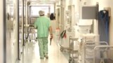 Doctor using scrubs walking at the hospital corridor