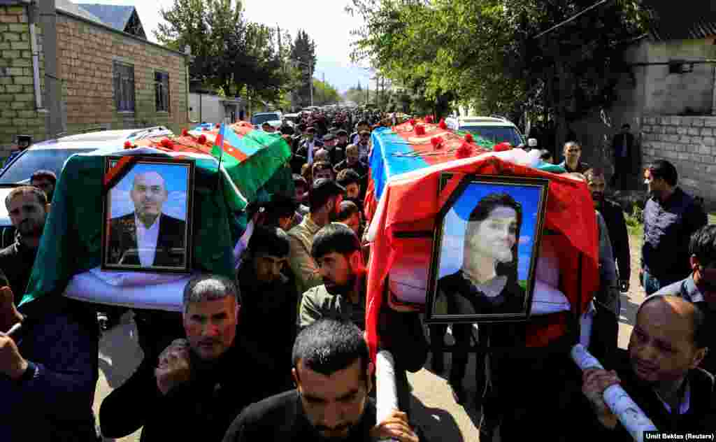 On October 12, residents of the western Azerbaijani town of Shamkir carry the coffins of Anar Aliyev and his wife, Nurcin Aliyeva, who were killed in an attack on the nearby city of Ganja, a metropolitan area of a few hundred thousand people. As of October 13, some 42 Azerbaijani civilians had been killed and 206 people injured by the fighting with Armenian and Karabakhi forces, according to the Azerbaijani government. It has not announced the number of military casualties.&nbsp;