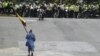 Venezuela -- A nun holding a Venezuelan flag walks towards a line of riot police during a protest against the government of President Nicolas Maduro in Caracas on June 7, 2017