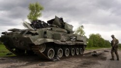 Украинский военный около подбитой российской техники, Харьковская область, 15 мая 2022