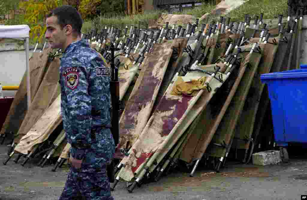 NAGORNO-KARABAKH -- A policeman walks past blood stained stretchers in the yard of the local morgue in Stepanakert, the main city of the breakaway region of Nagorno-Karabakh, November 6, 2020