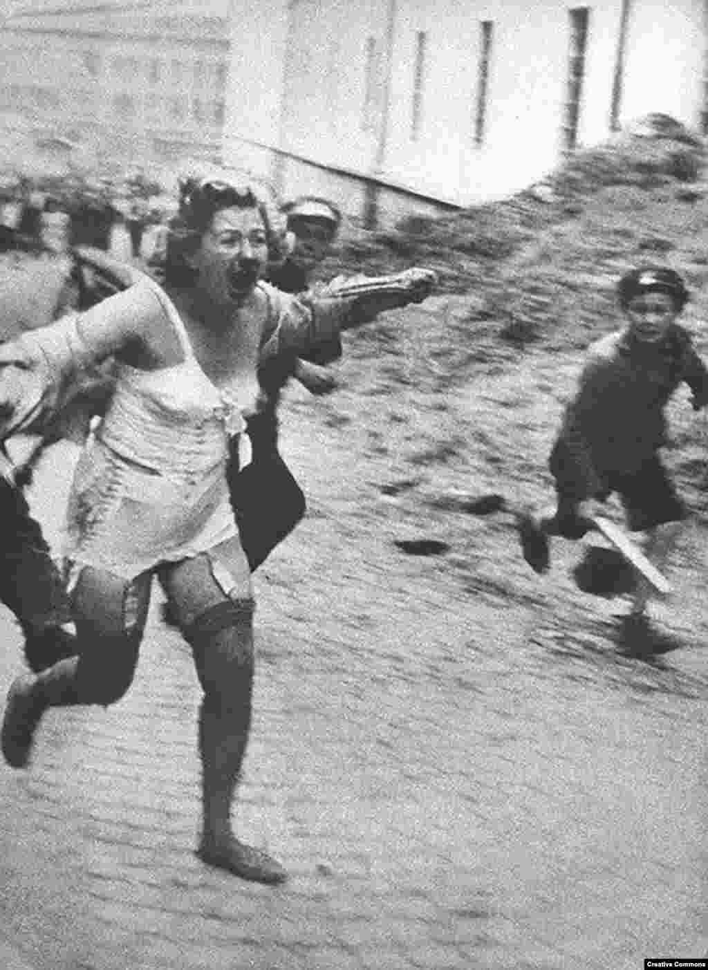 Еврейка убегает от толпы во Львове, городе, который в межвоенное время был польским, затем оккупирован СССР, а после нацистами. Фото сделано в июне или июле 1941 года. При активном поощрении нацистов евреи советской Украины и других оккупированных территорий проживали настоящие ужасы. Тысячи из них были замучены и убиты в ходе погромов, устроенных в Центральной и Восточной Европе