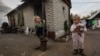 Seven-year-old Diana and 3-year-old Herman play outside a house 70 meters (230 feet) from a Ukrainian army frontline position in the Donetsk region in 2019. 