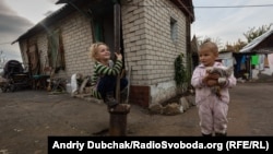 Seven-year-old Diana and 3-year-old Herman play outside a house 70 meters (230 feet) from a Ukrainian army frontline position in the Donetsk region in 2019. 