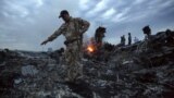 UKRAINE – People walk amongst the debris at the crash site of a passenger plane near the village of Grabove in the Donetsk region, July 17, 2014