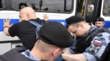 Russian police officers detain a protester during a march to protest against the alleged impunity of law enforcement agencies