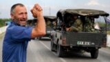 GEORGIA -- A local resident greets Georgian troops moving into the city of Tskhinvali, 100 km (62 miles) from Tbilisi, August 8, 2008. Georgian troops, backed by warplanes, pounded separatist forces on the outskirts of the South Ossetian capital on Friday