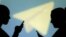 ILLUSTRATION -- Silhouettes of mobile users are seen next to a screen projection of Telegram logo in this picture illustration taken March 28, 2018. 