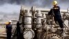 FILE - In this Dec. 13, 2009 file photo, Iraqi workers are seen at the Rumaila oil refinery, near the city of Basra, 340 miles (550 kilometers) southeast of Baghdad, Iraq.