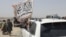 PAKISTAN - People wave a Taliban flag as they drive through the Pakistani border town of Chaman on July 14, 2021, after the Taliban claimed they had captured the Afghan side of the border crossing of Spin Boldak along the frontier with Pakistan