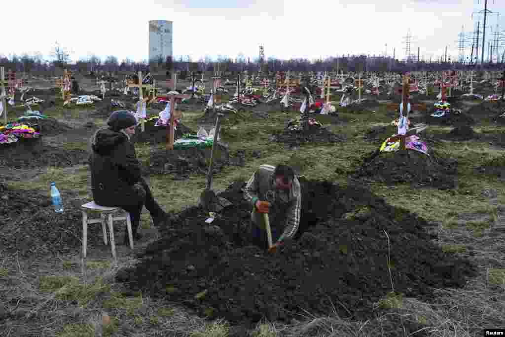Могильщик на кладбище в Донецке копает яму для захоронения одного из 34 погибших во время взрыва метана в шахте имени Засядько 4 марта &nbsp;