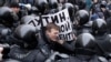 RUSSIA -- Riot police officers detain a protester holding a poster reading 'Putin, you are not my President' during a rally in St. Petersburg, January 28, 2018