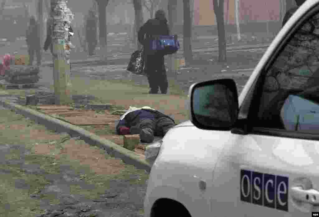 Машина ОБСЕ возле тела погибшего на улице Мариуполя