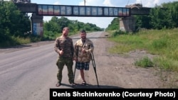Денис Щинкоренко (слева) и Андрей Камаев на фоне моста с надписью "Новороссия". Сентября 2015, восток Украины