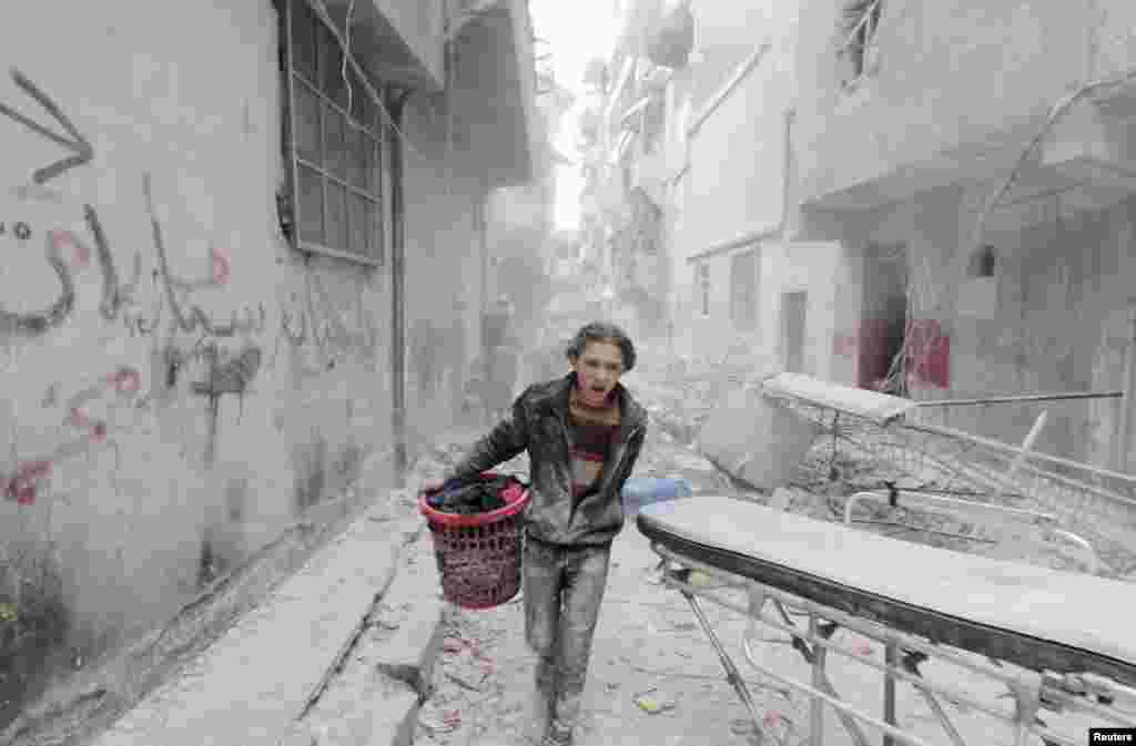 Сирийский мальчик спасается бегством после того, как верные правительству Башара Асада силы начали серию обстрелов Алеппо 2 апреля