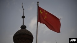 Китайский флаг на фоне мечети в Синьцзяне