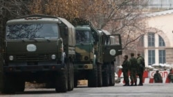 Вооруженные люди и военные машины вблизи контрольно-пропускного пункта на территории, контролируемой самопровозглашенной ДНР