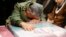 IRAN -- A handout picture provided by the office of Iran's Supreme Leader Ayatollah Ali Khamenei shows an unidentified Revolutianary Guard commander paying over the caskets of slain Iranian military commander Qasem Soleimani during a funeral ceremony at T