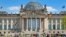 BERLIN, GERMANY - APR 28, 2018: People relaxing on the grass in front of the Reichstag building, seat of the German Parliament (Deutscher Bundestag)