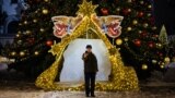RUSSIA -- A man takes a picture of himself in front of Christmas decorations near the Cathedral of Christ the Savior in central Moscow, December 27, 2020
