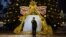 RUSSIA -- A man takes a picture of himself in front of Christmas decorations near the Cathedral of Christ the Savior in central Moscow, December 27, 2020