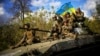 UKRAINE – Ukrainian soldiers sit on an armoured vehicle as they drive on a road between Izium in Kharkiv Oblast and the city of Lyman in Donetsk Oblast, October 4, 2022 