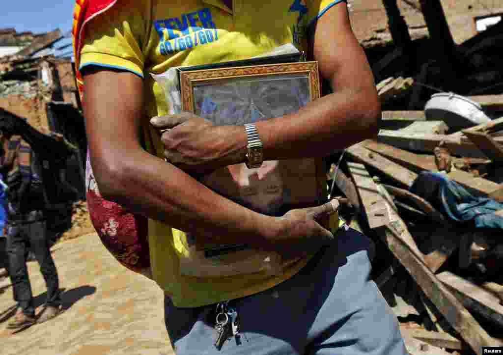 Житель Бактапура с фотографией погибшего при землетрясении родственника, Непал