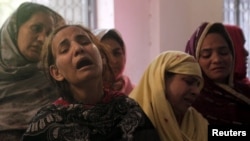 Члены семьи оплакивают родственника, погибшего при взрыве в Лахоре