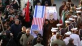 IRAN -- Mourners carry mock coffins with images of US President Donald Trump and Israeli Prime Minister Benjamin Netanyahu pasted on them as they gather to pay homage to slain Iranian military commander Qasem Soleimani, Iraqi paramilitary chief Abu Mahdi 