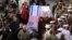 IRAN -- Mourners carry mock coffins with images of US President Donald Trump and Israeli Prime Minister Benjamin Netanyahu pasted on them as they gather to pay homage to slain Iranian military commander Qasem Soleimani, Iraqi paramilitary chief Abu Mahdi 