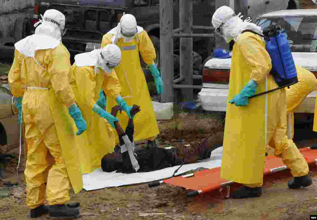 Медики похоронной команды забирают тело погибшего предположительно от лихорадки Эбола. Моровия, Либерия.&nbsp;9 сентября 2014 