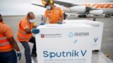 Рабочие разгружают "Спутник V" в аэропорту Каракаса