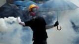 Hong Kong --An anti-government protester holding an umbrella throws a tear gas canister during a demonstration at Causeway Bay district in Hong Kong, China September 29, 2019