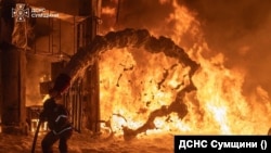Пожарный тушит огонь на запревке в Сумской области после российского обстрела, 23 июля 2026 года