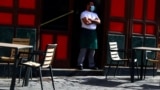 Madrid, Spain - A waiter wearing a protective face mask waits for customers in his terrace amid the outbreak of the coronavirus disease (COVID-19)