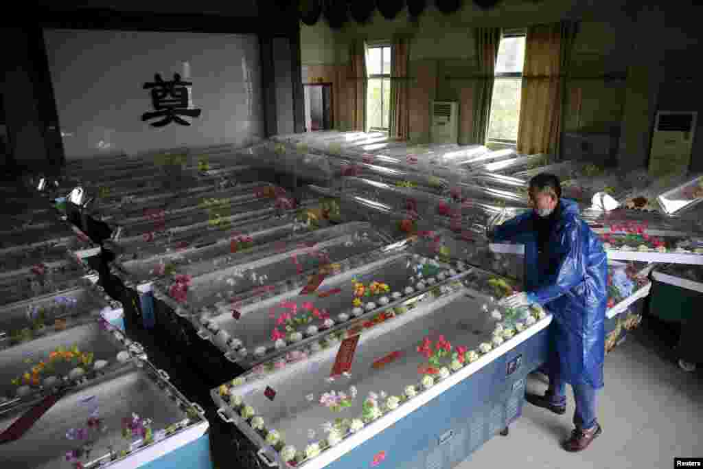 Сотрудник морга готовит гробы для погибших в крушении прогулочного теплохода на реке Янцзы