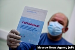 A man shows his vaccination certificate after getting a shot of Russia's Sputnik V coronavirus vaccine in Moscow on December 28, 2020.
