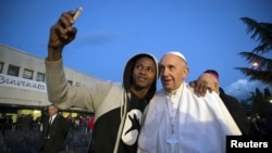 Папа Франциск фотографируется с мигрантом